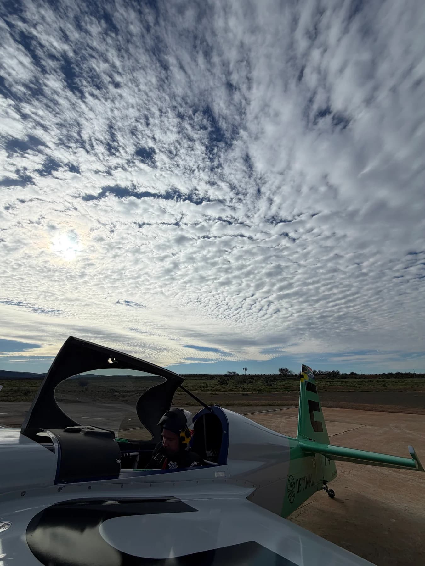 The Edge 540 on the apron beneath textured clouds