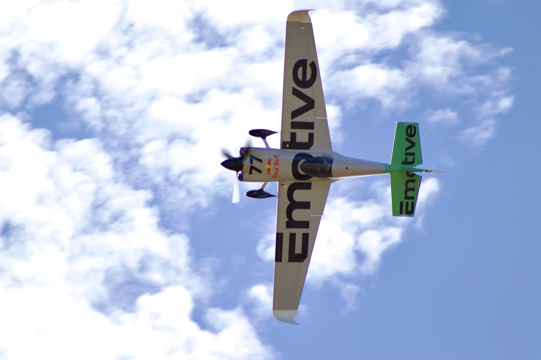 Underside view of Patrick Davidson’s Emotive-liveried number 77 Edge 540 V3 in flight, with Red Bull branding visible.
