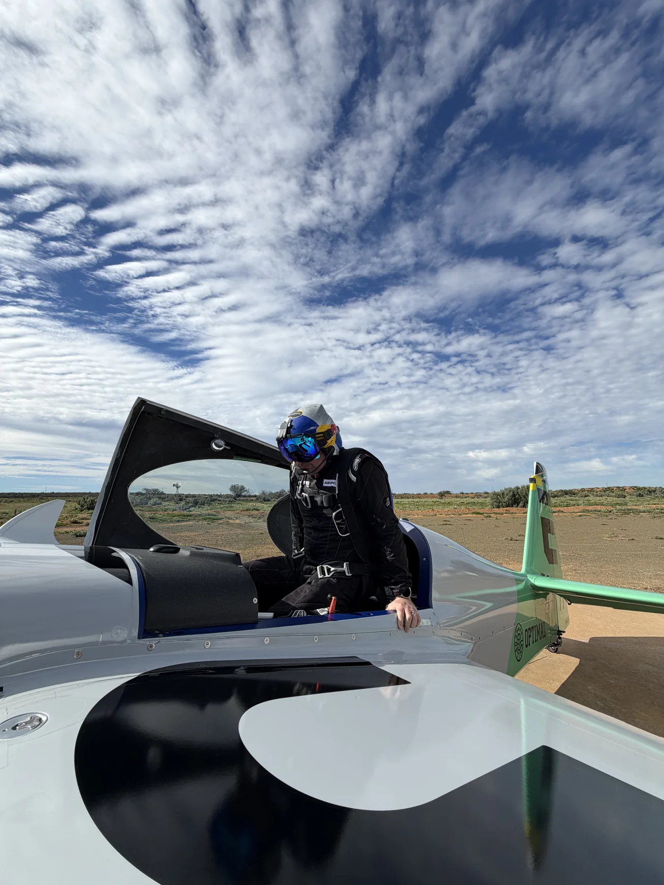Patrick Davidson in the cockpit of the Emotive-liveried race aircraft with the canopy open.